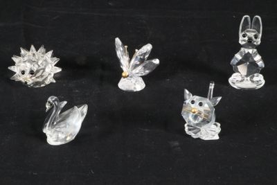 six figurines en verre transparent représentant des animaux et des oiseaux sur fond noir