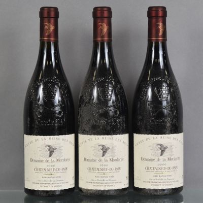 Trois bouteilles de vin sont alignées sur une table en verre
