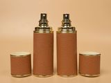 three brown leather bottles with gold lids and a gold cap