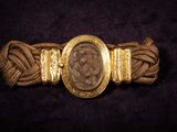 a gold bracelet with a picture of a woman on it