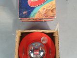 a box with a toy in it and a red frisbee in it