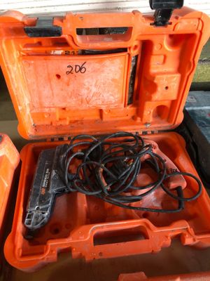 une boîte à outils orange contenant un cordon d'alimentation et une perceuse