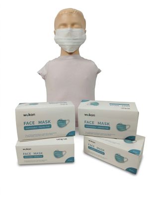 trois boîtes de masques faciaux et une tête de mannequin sur fond blanc