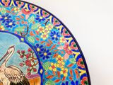 une assiette colorée sur laquelle est représenté un oiseau