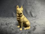 a small statue of a dog sitting on a black surface