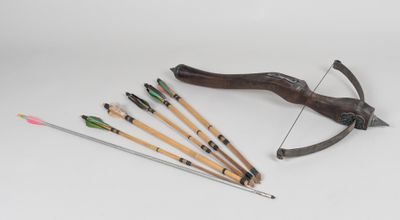 a bow, arrows and a bow rest on a white surface