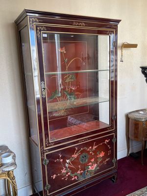 une armoire avec une porte en verre ornée d'un motif floral