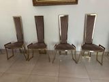 four chairs are lined up in a row in front of a painting
