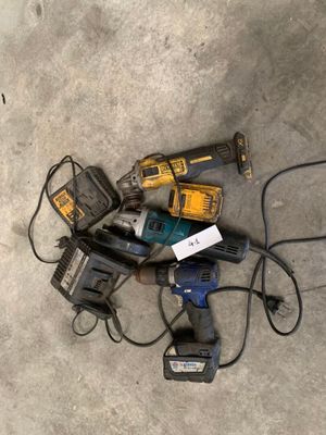 un tas d'outils électriques posés par terre à côté d'un câble d'alimentation