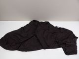 a black jacket laying on a white table next to a lamp