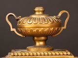 a gold vase sitting on top of a wooden table