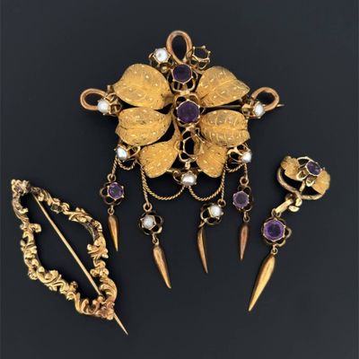 un gros plan sur une broche en or accompagnée d'un assortiment de bijoux