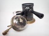 an old fashioned tea kettle and a cup on the table