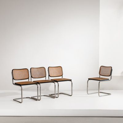 quatre chaises dans une pièce blanche aux murs blancs et au sol blanc