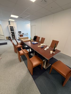 une longue table avec des chaises et une bouteille de vin posée dessus