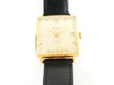 an image of a gold plated wrist watch with a black leather strap
