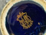 a blue and gold plate with a gold emblem on it