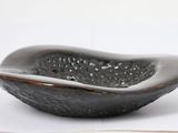 a black bowl sitting on top of a table next to an open book