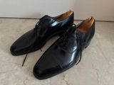 men ' s black leather shoes with laces on a marble floor