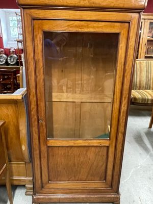 un meuble en bois avec une porte en verre au milieu d'une pièce