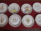 nine plates with different designs on them on a red table