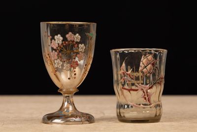 two glasses sitting on a table with a black background