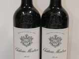 two bottles of red wine sitting next to each other on a table