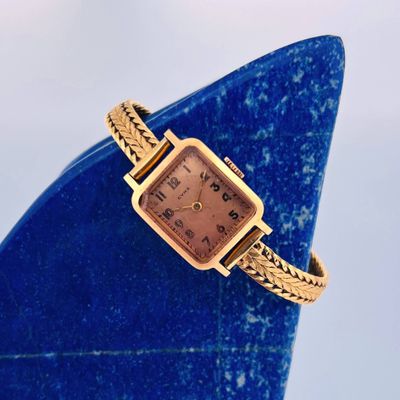 an image of a gold watch on a blue vase