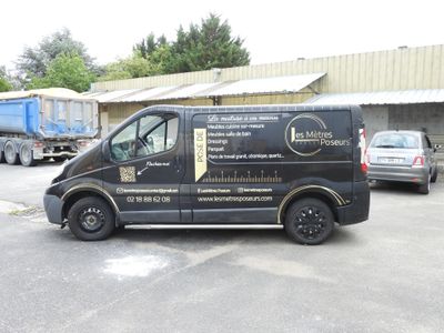 a black van parked in a parking lot next to a building
