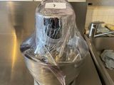 stainless steel counter top with a blender wrapped in plastic and a sink in the background