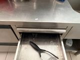 stainless steel counter top with utensils and pans in it