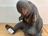 a statue of a monkey sitting on a wooden floor
