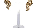 a close up of a pair of earrings on a stand