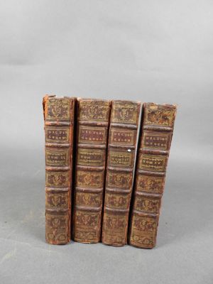 quatre vieux livres sont empilés les uns sur les autres sur une table
