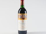 the bottle of wine is sitting on a white surface