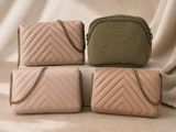 three pink and green bags sitting on top of each other