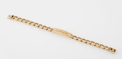 a yellow gold bracelet with a curb link on a white background