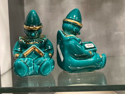 two figurines that are sitting on a glass shelf