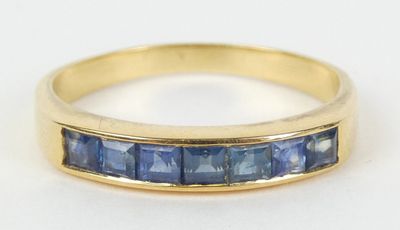 un gros plan d'une bague en or jaune sertie de saphirs bleus
