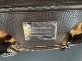 leopard print purse with a metal plaque on the front