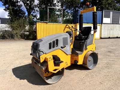 une petite machine jaune qui est posée dans la terre