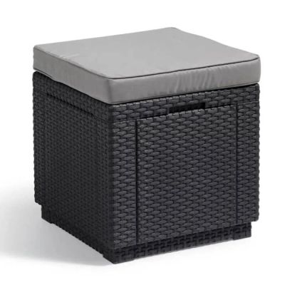 un pouf en osier noir surmonté d'un coussin gris