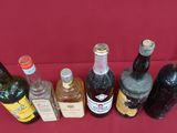 several bottles of alcohol are lined up on a red table