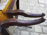 two brown handles on a wooden bench on a cobblestone street