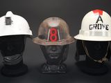 three hard hats on display on a black background