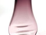 a purple glass vase sitting on a white surface