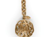 a close up of a gold necklace with a coin on it