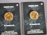 deux cartes sur lesquelles figure une pièce d'or, posées sur une table