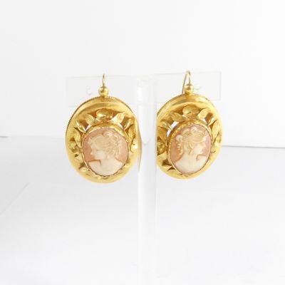 une paire de boucles d'oreilles dorées ornées d'un camée