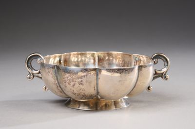 an antique silver bowl with handles and handles on a table